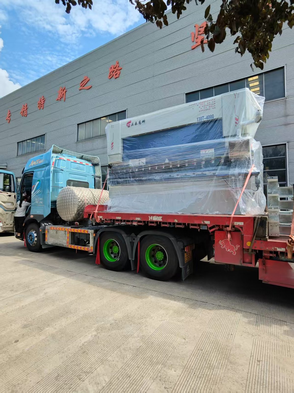 ZTGAOKE 130T 4000mm electro-hydraulic CNC press brake wrapped in export film on a flatbed truck with 130T-4000 model plate